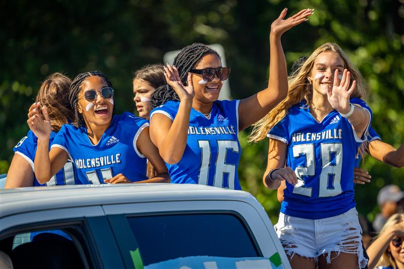 Students ride on a homecoming parade float